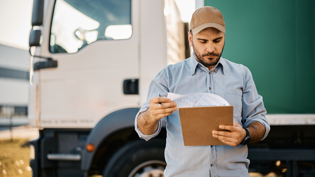 Truck driver going through paperwork before the ride.