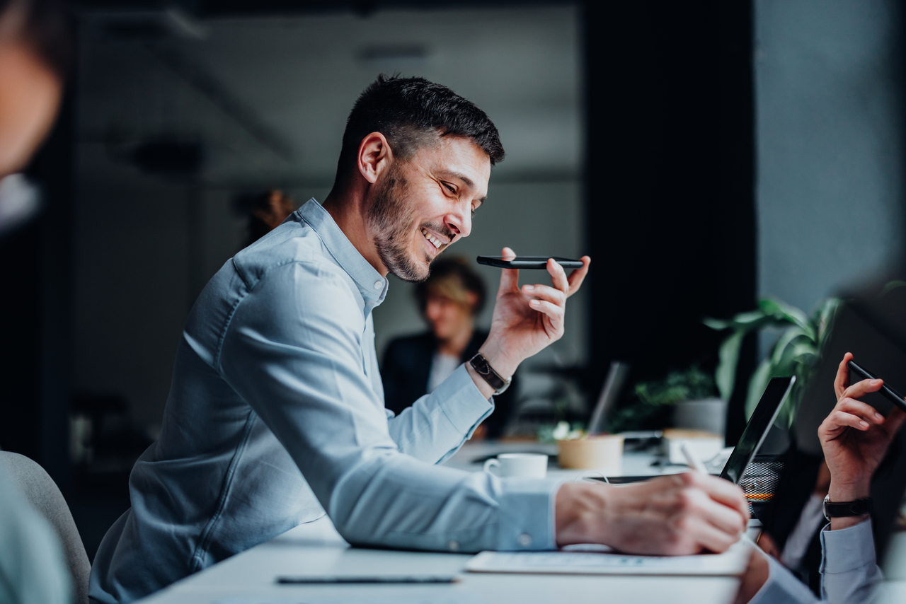 Happy Business Man Talking On A Mobile Phone In A Modern Office